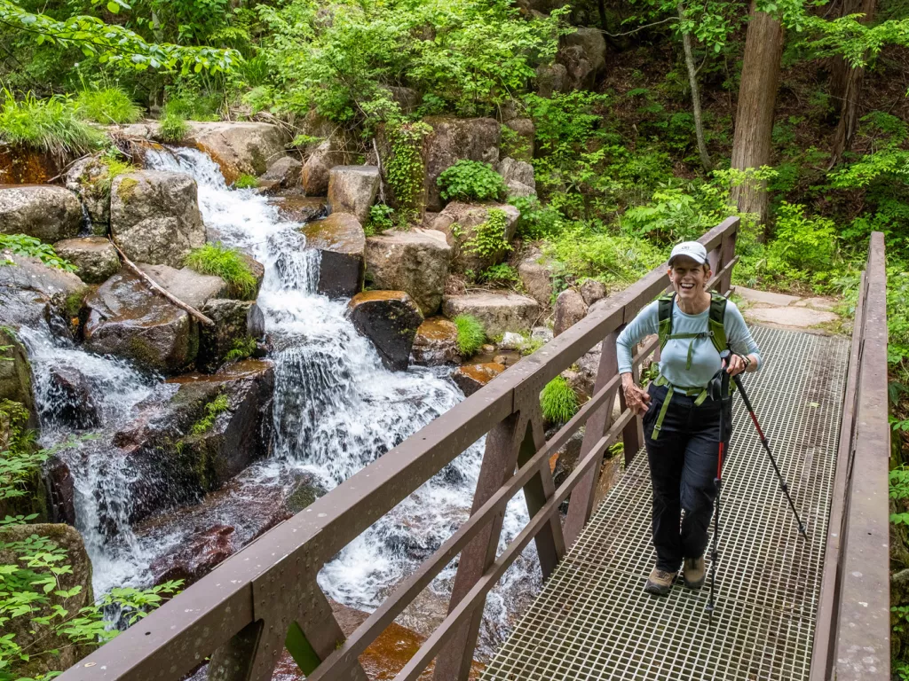 Woman standing on a bridge in front of a waterfall