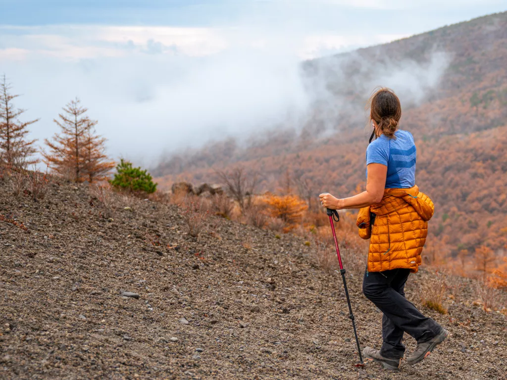 Woman ascending on a rocky, foggy hill