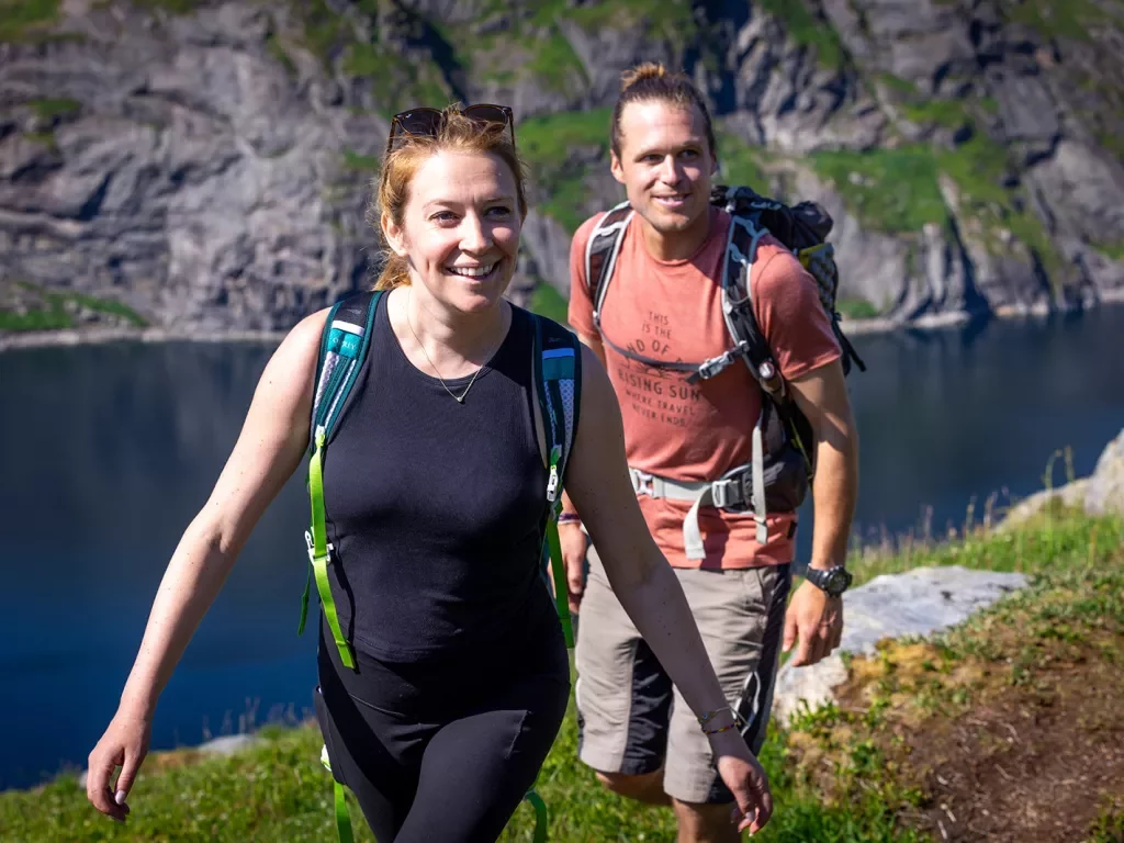 Man and women with backpacks ascending a mountain