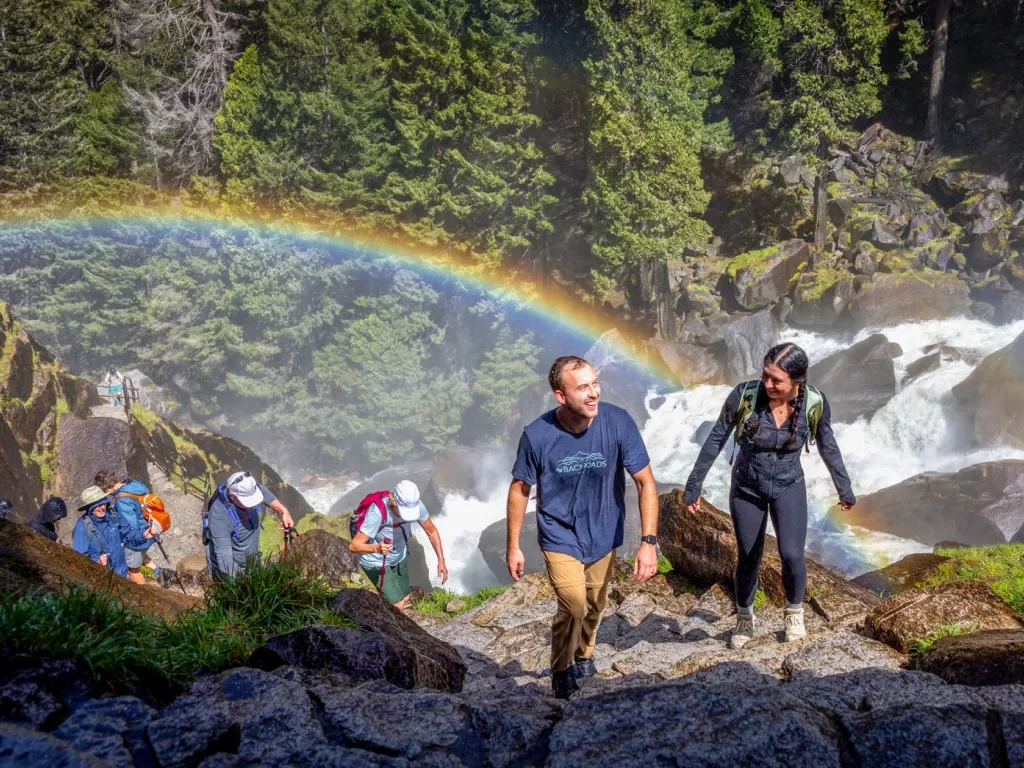 a rainbow behind a group of hikers