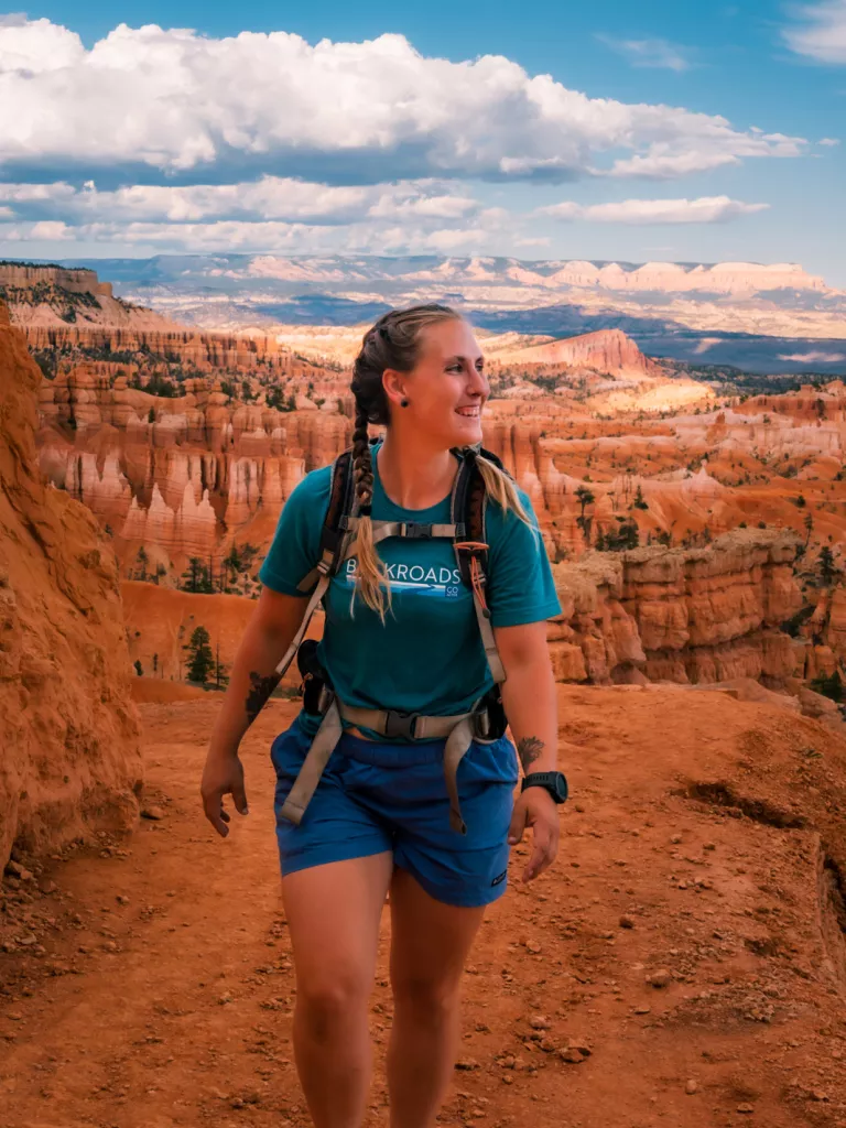 Woman smiling and ascending a red, rocky hill