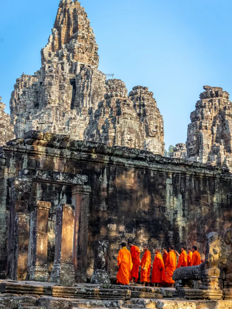 Group of monks walking into ancient temple ruins