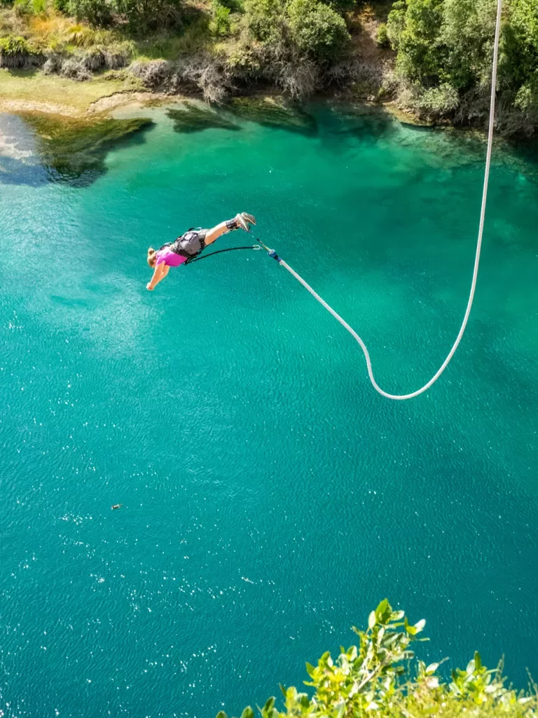 person bungee jumping into water