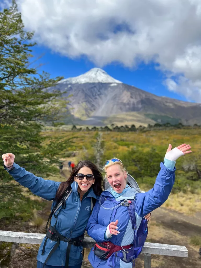 Two Guests pose with a volcano on a hike