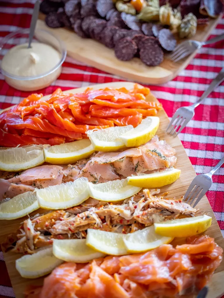 Wooden plank full of cured fish and lemon slices